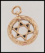 A hallmarked 9ct gold star of David pendant with scrolled engraving. Hallmarked Birmingham. Weight
