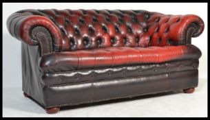 A Victorian style Chesterfield two seater ox - blood leather sofa, upholstered in ox - blood
