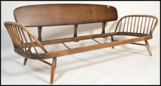 A mid century Ercol beech and elm wood studio day bed / sofa settee. Raised on shaped legs with show