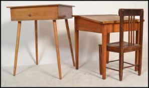A pair of mid century Industrial / school desks in light beech wood construction, both having hinged