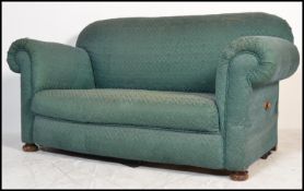 A 19th Century Victorian drop end two seater sofa in the manner of Howard & Sons, raised on turned