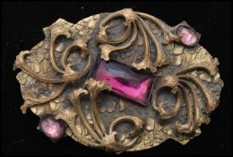 A 1920s large Czech Art Nouveau gold-tone brooch set with large faceted amethyst glass stone