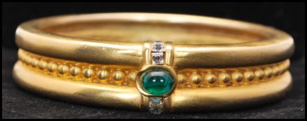 A vintage signed Givenchy runway gold-tone bangle bracelet set with an emerald green Gripoix