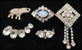 A collection of vintage paste brooches to include an elephant, faux opal and dangle brooch. Largest