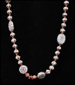 A 1920s Czech uranium glass bead necklace strung with Chinese script moulded beads, terracotta