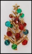 A signed Hollycraft gold-tone Christmas tree brooch pin set with a rhinestone and glass baubles.