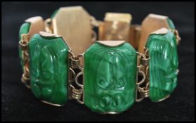 A 1950's gold tone bracelet set with translucent  green glass/ lucite scarab beetle links having a
