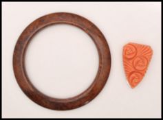 A 1920's carved bakelite dress clip together with a 1930s brown bakelite bangle. Diameter 3 1/4
