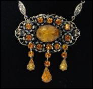 A 1930's Czech amber glass drop necklace having a decorative floral metal chain with large