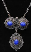 A 1960s silver-tone filigree bracelet and necklace set. The bracelet having four links with blue and