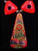A signed 1920s red glass bead necklace strung with a tribal pendant with triangular rhinestone set