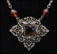 A 1920s Czech dark amber faceted glass bead and filigree work  pendant necklace with stylised