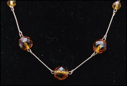 An early 20th century rolled gold and topaz glass necklace with hook fastener. Measures 16 inches.