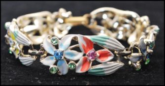 A 1950's silver tone metal bracelet and earring set having rhinestone and enamel decoration.