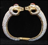 A 1990s signed Kenneth J Lane rams head clamper bracelet bangle with enamel and red cabochon