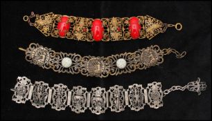 A 1920s Czech panel bracelet decorated with vines, red cabochons and red rhinestones, measures 7 1/2