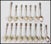 A collection of silver souvenir teaspoons with orn
