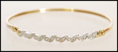 A 9ct hall marked gold bangle with a hook and fast