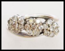 An 18ct white gold triple cluster crossover ring h