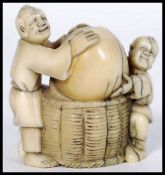 JAPANESE MEIJI PERIOD IVORY NETSUKE DEPICTING TWO ACTORS WITH BASKET & NUT
