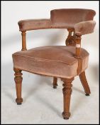 A 19th century Victorian oak office industrial desk / arm chair raised on turned legs with carved