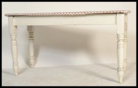A Victorian painted pine country dining table being raised on turned legs with fitted frieze,