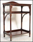A Victorian mahogany twin tier side table in the manner of EW Godwin. The squared legs with canted