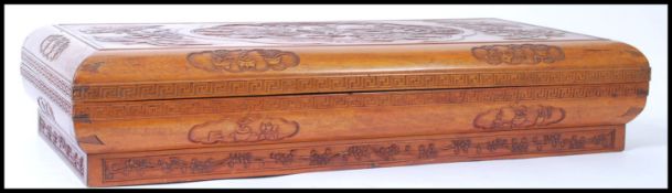 A 20th Century Chinese wooden robe box, with carved cartouche decoration having a dragon and