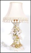 A Sitzendorf ceramic table lamp featuring three cherub figurines around a central naturalistic