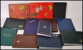 A group of twelve vintage postcard albums and sleeves.