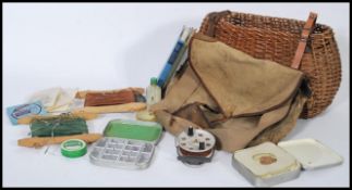 A vintage 20th century wicker fishing hamper bag with canvas hamper stocked with various fishing