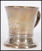 A hallmarked silver early 20th century tankard cup raised on a circular base with shaped handle. The