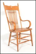 A 20th century American Windsor style country oak armchair raised on turned legs united by stretcher