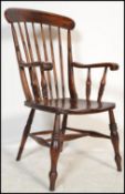 A Victorian 19th century beech and elm wood windsor chair / armchair being raised on turned legs