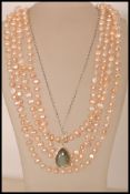 A string of  real pearls with a pink hue measuring approx 100 inches, along with a stamped 925