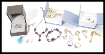 A selection of jewellery to include a stamped 925 silver ring with a central blue stone and a halo