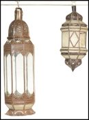 A pair of 20th century Morroccan lanterns /  lamps with inlaid glass panels, one having a pedestal