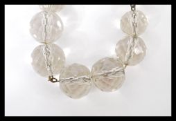 A ladies clear glass beaded necklace having graduating faceted beads. Measures 34 inches.