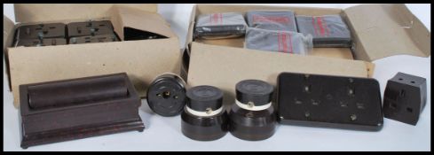A group of vintage early 20th century new old stock bakelite light switches and plugs complete in