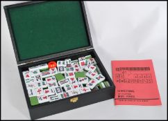 A 20th century Chinese Mahjong set in fitted case having white and green stone playing pieces.