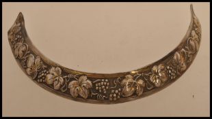 A silvertone metal bandeau necklace with embossed vines in the classical style.