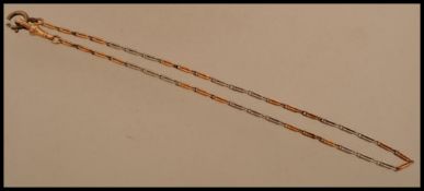 An 18ct gold albert chain having an alternating yellow and white gold chain with hook and bolt