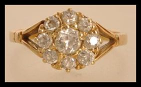 An 18ct gold and diamond ring having a central diamond with a halo of smaller diamonds. Approx