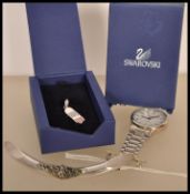 A Swarovski silver charm / pendant in the form of a skateboard with inlaid blue and red crystals,