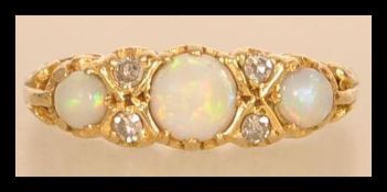 An hallmarked 18ct gold opal and diamond ring having three opal cabochons with four diamond spacers.
