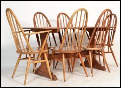 A retro mid 20th century Ercol refectory dining table and chairs being raised on angled tapering