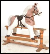 A 20th century antiques style childs upholstered rocking horse. Raised on a solid wooden glider with
