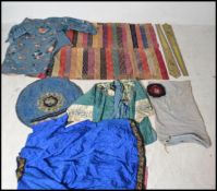 A collection of 19th century Chinese clothing to include a blue silk shirt with flowers and