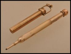 A hallmarked 9ct gold propelling pencil by G Mordan and Co being contained within a pendant.