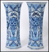 A pair of 18th Century Dutch trumpet form delft vases, with a hand painted blue and white pattern of